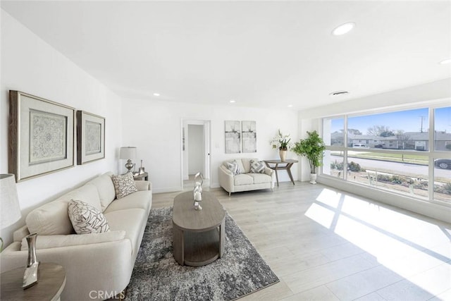 living area featuring light wood-type flooring and recessed lighting