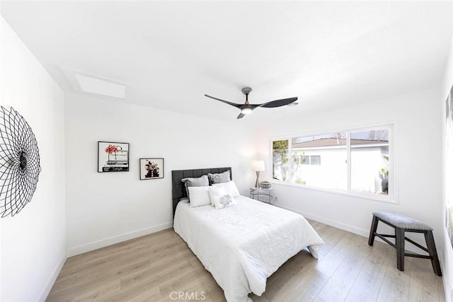 bedroom with ceiling fan, light wood-style flooring, and baseboards