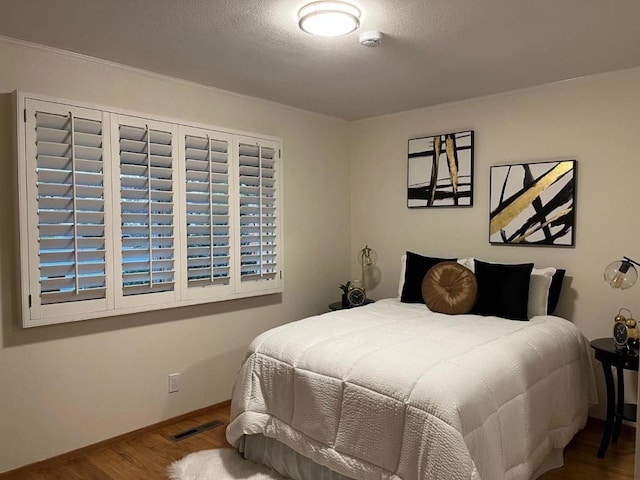 bedroom featuring hardwood / wood-style floors and a textured ceiling