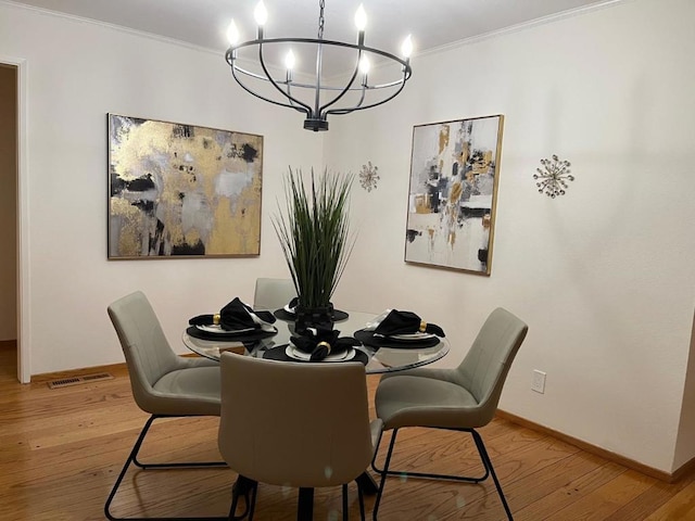 dining room featuring a notable chandelier, wood-type flooring, and ornamental molding