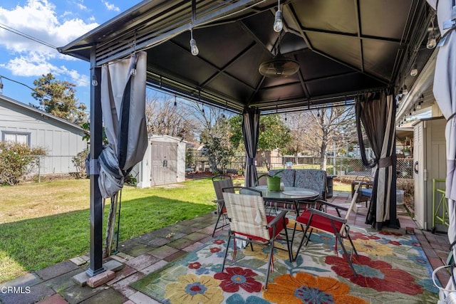 view of patio / terrace featuring outdoor dining space, a storage unit, and a fenced backyard