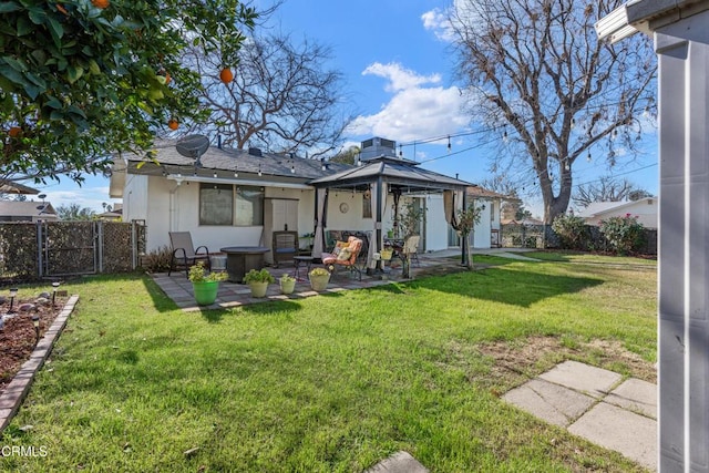 back of property featuring stucco siding, a lawn, fence, a gazebo, and a patio area