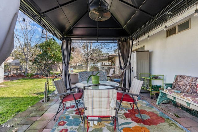 view of patio / terrace with a gazebo, outdoor dining space, and fence