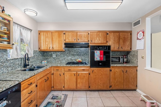 kitchen featuring light tile patterned floors, visible vents, a sink, black appliances, and under cabinet range hood