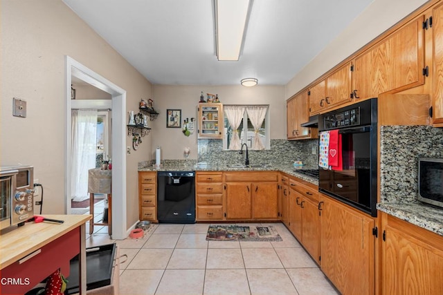 kitchen featuring light tile patterned floors, plenty of natural light, black appliances, and a sink