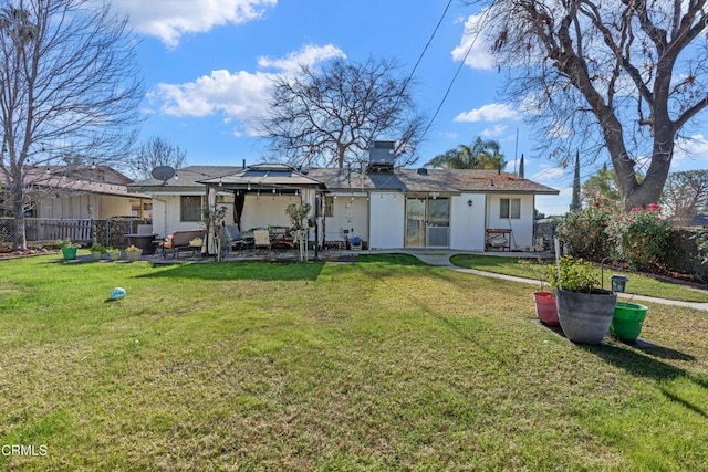 rear view of house with a yard, fence, and a patio area