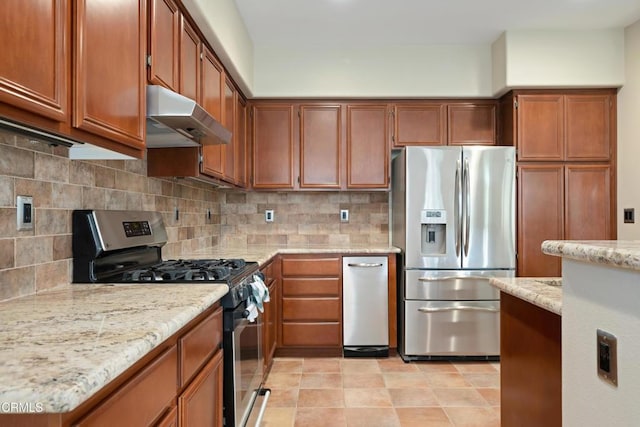 kitchen featuring light stone counters, backsplash, and appliances with stainless steel finishes