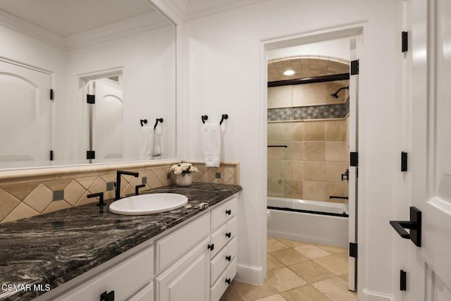 bathroom featuring tasteful backsplash, enclosed tub / shower combo, vanity, and crown molding