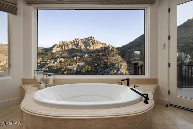 bathroom featuring a mountain view, a wealth of natural light, and tile patterned floors