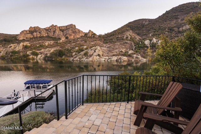 exterior space with a water and mountain view and a boat dock