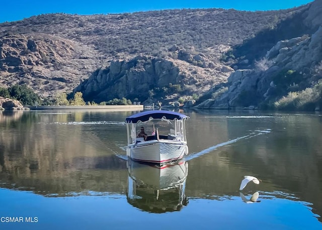 view of dock with a water and mountain view