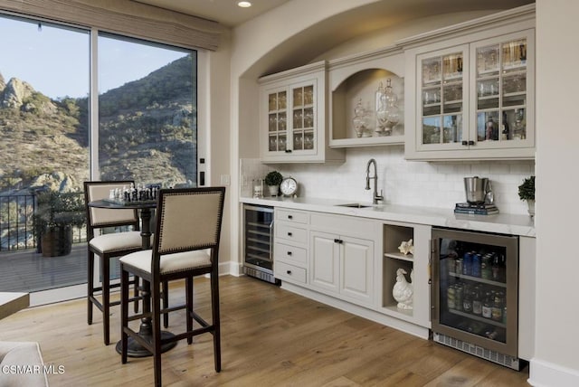 bar featuring white cabinetry, beverage cooler, and a mountain view