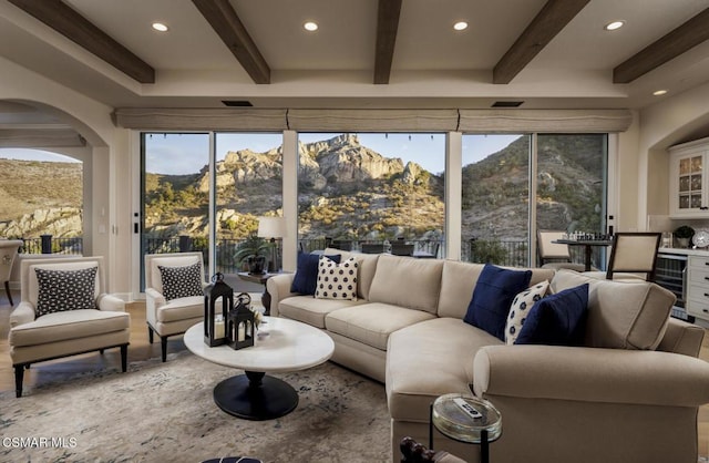 living room with beamed ceiling, a mountain view, hardwood / wood-style floors, and wine cooler