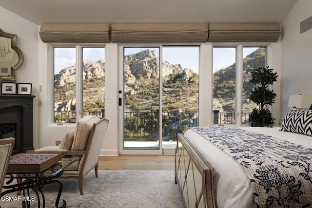 bedroom featuring multiple windows, access to exterior, and a mountain view