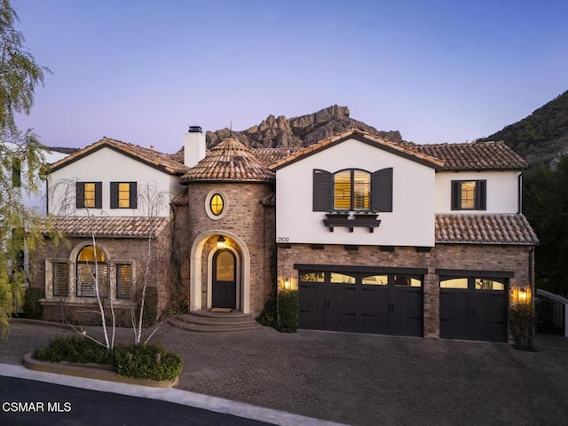 mediterranean / spanish-style home featuring a garage and a mountain view