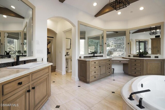 bathroom featuring vaulted ceiling, a wealth of natural light, and vanity