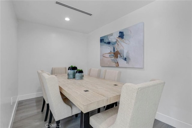 dining area with visible vents, baseboards, and wood finished floors