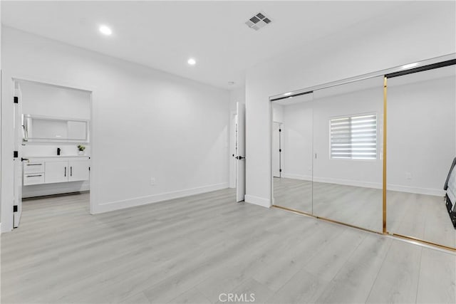 unfurnished bedroom with light wood-style flooring, recessed lighting, visible vents, baseboards, and a closet