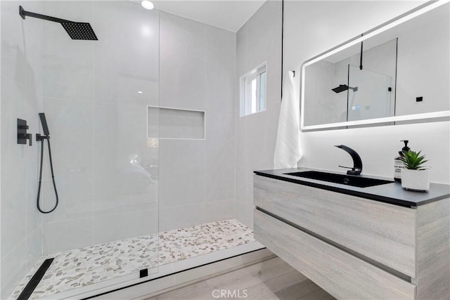 bathroom featuring a walk in shower, wood finished floors, and vanity