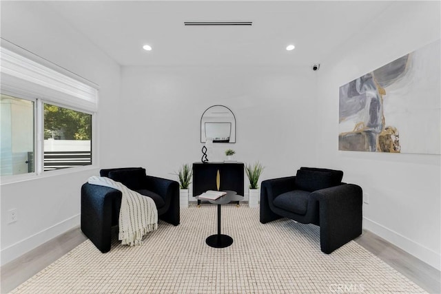 sitting room with visible vents, baseboards, wood finished floors, and recessed lighting