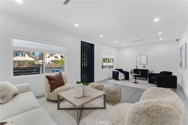 living room featuring recessed lighting, baseboards, and wood finished floors