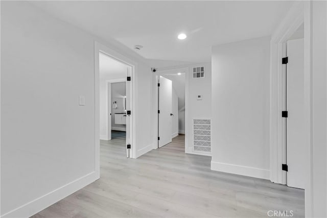 spare room with visible vents, light wood-style flooring, and baseboards