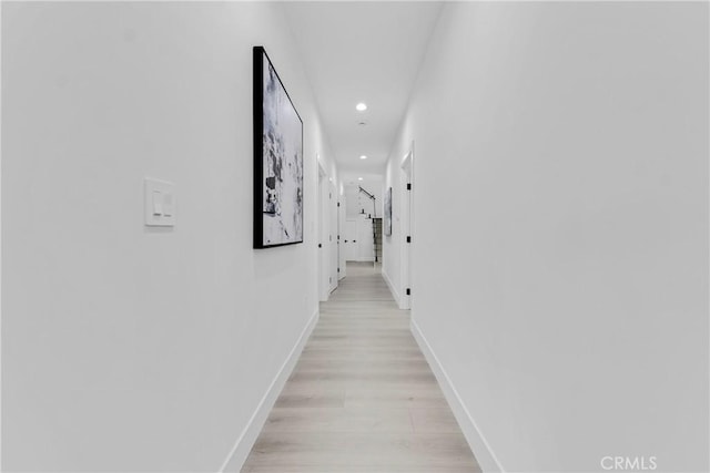 hall with light wood-type flooring, baseboards, and recessed lighting