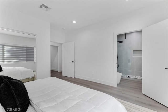 bedroom with recessed lighting, visible vents, connected bathroom, wood finished floors, and baseboards