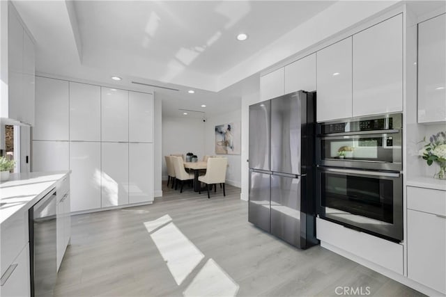 kitchen featuring light countertops, appliances with stainless steel finishes, modern cabinets, and white cabinetry