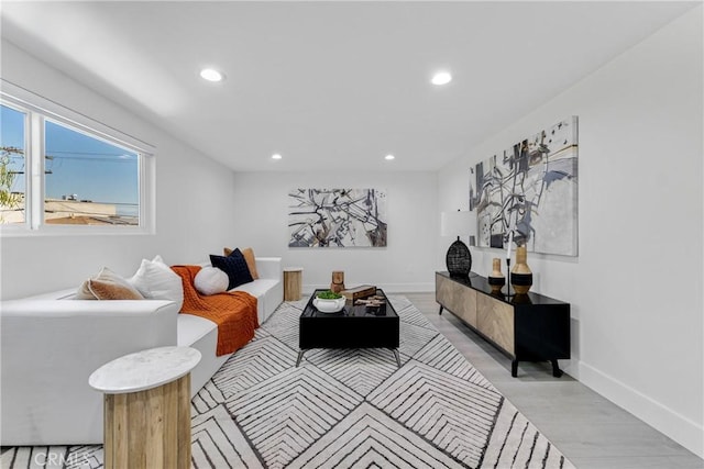 living area with light wood-type flooring, baseboards, and recessed lighting