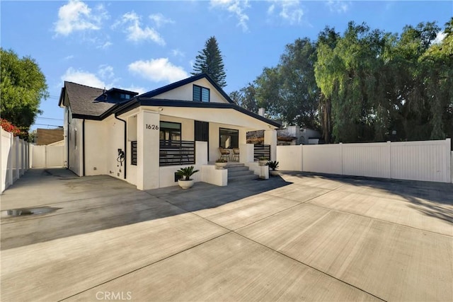 bungalow with fence private yard, covered porch, and stucco siding