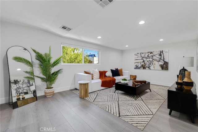 living room featuring baseboards, wood finished floors, visible vents, and recessed lighting