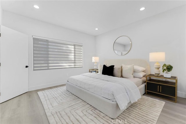 bedroom featuring baseboards, light wood-type flooring, and recessed lighting