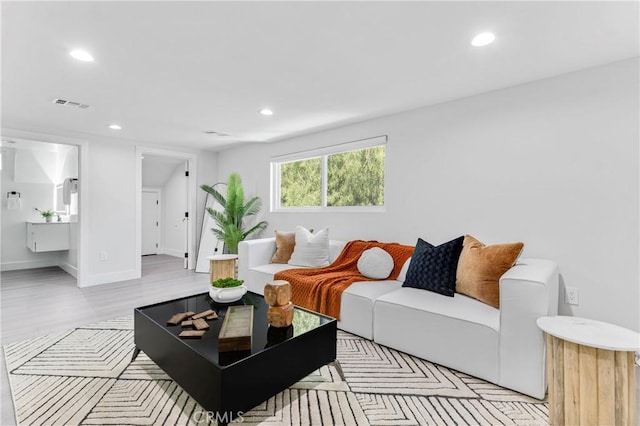 living area featuring light wood-type flooring, baseboards, visible vents, and recessed lighting