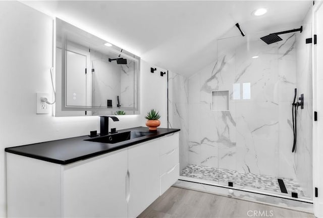 full bath with recessed lighting, a marble finish shower, wood finished floors, and vanity