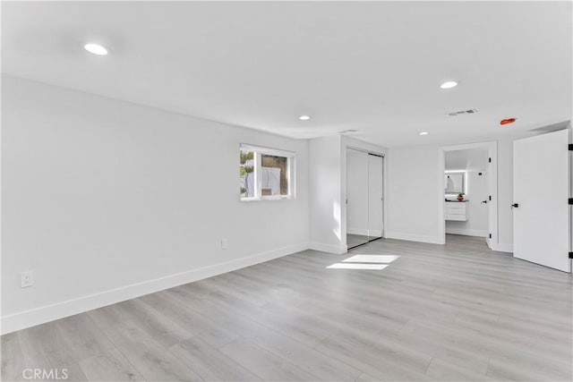 unfurnished living room featuring baseboards, visible vents, and light wood finished floors