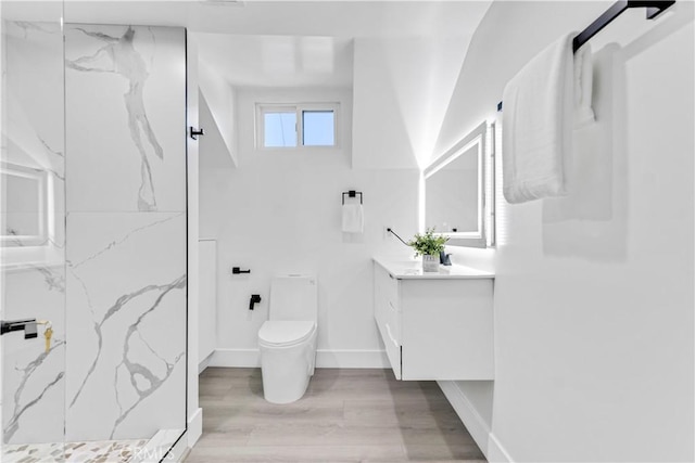 full bathroom featuring toilet, wood finished floors, vanity, baseboards, and a marble finish shower