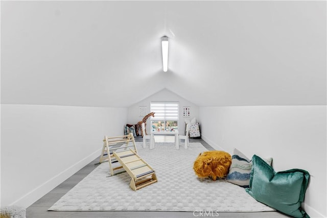 recreation room with lofted ceiling, baseboards, and wood finished floors