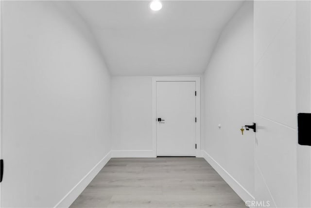 additional living space featuring light wood-type flooring, baseboards, and lofted ceiling