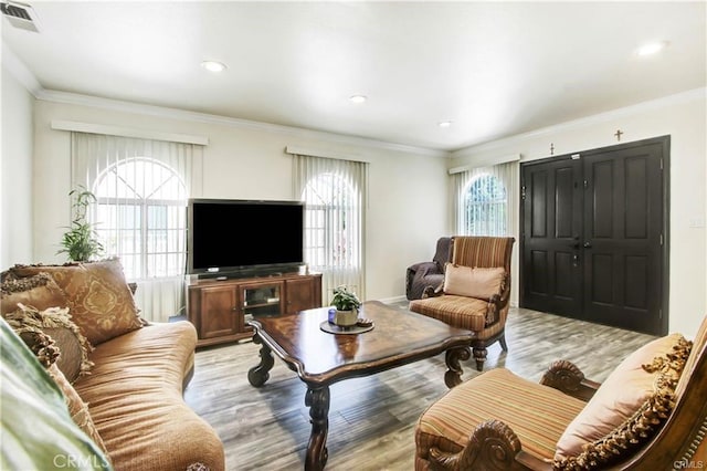 living room with ornamental molding and light hardwood / wood-style flooring