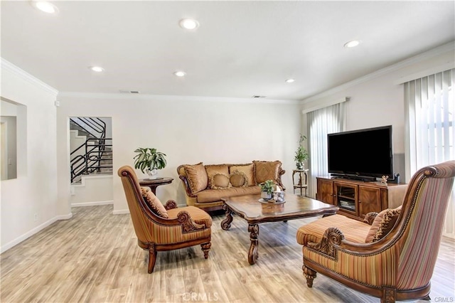 living room with crown molding, light hardwood / wood-style flooring, and a healthy amount of sunlight