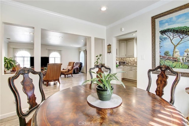 dining space with crown molding and light wood-type flooring