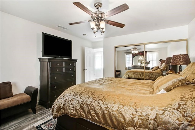 bedroom with hardwood / wood-style floors, a closet, and ceiling fan