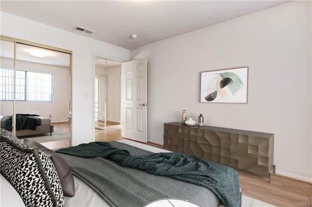 bedroom with wood-type flooring and a closet