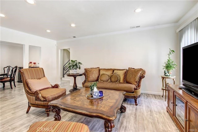 living room featuring ornamental molding and light hardwood / wood-style flooring