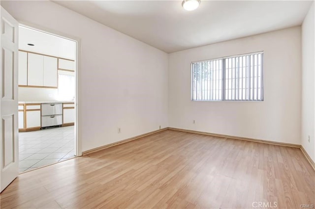 empty room with a healthy amount of sunlight and light hardwood / wood-style flooring