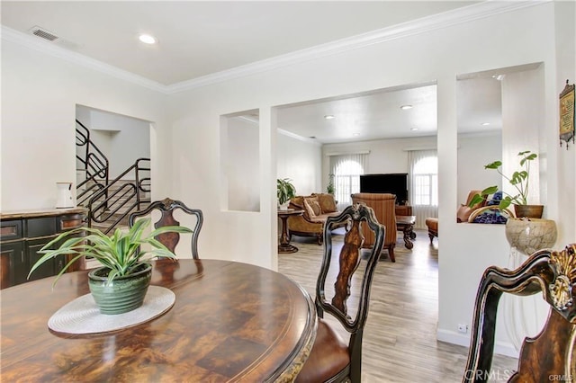 dining room featuring ornamental molding and light hardwood / wood-style flooring