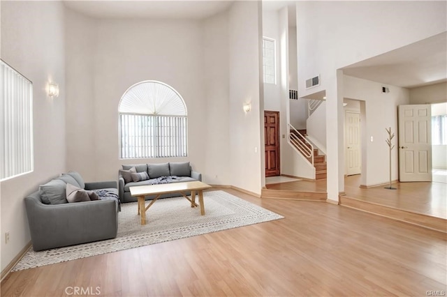 living room with wood-type flooring and a high ceiling