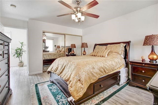 bedroom with a closet, ceiling fan, and light wood-type flooring