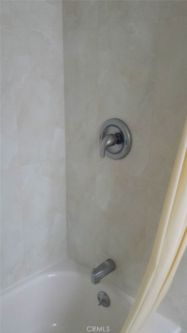 bathroom with shower / bath combo with shower curtain